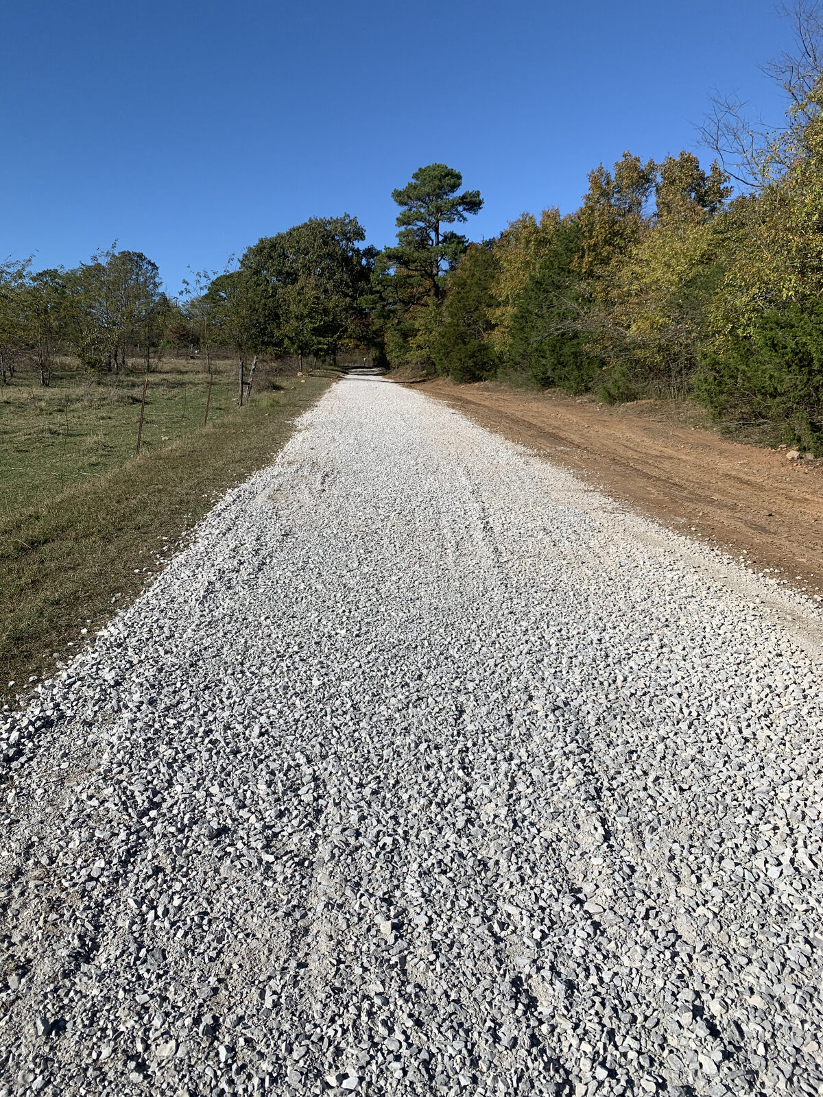 Long gravel driveway after grading and spreading in Arkansas